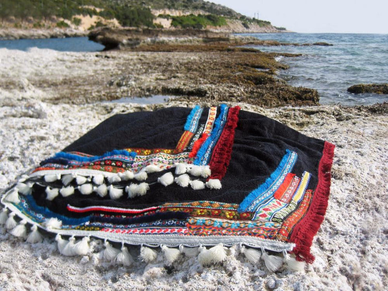 Beach towel in black color with woven ribbons and tassels