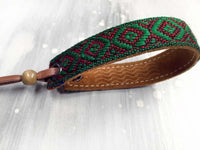 Leather bracelet with a green woven ribbon and Aztec pattern