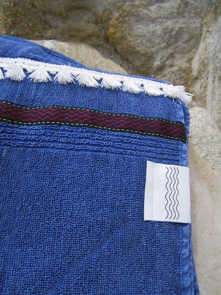 Peshtowel/towel in denim stonewashed color with a woven ribbon and a fringed band